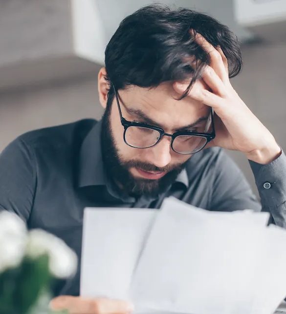 Man in glasses looking at his debt.