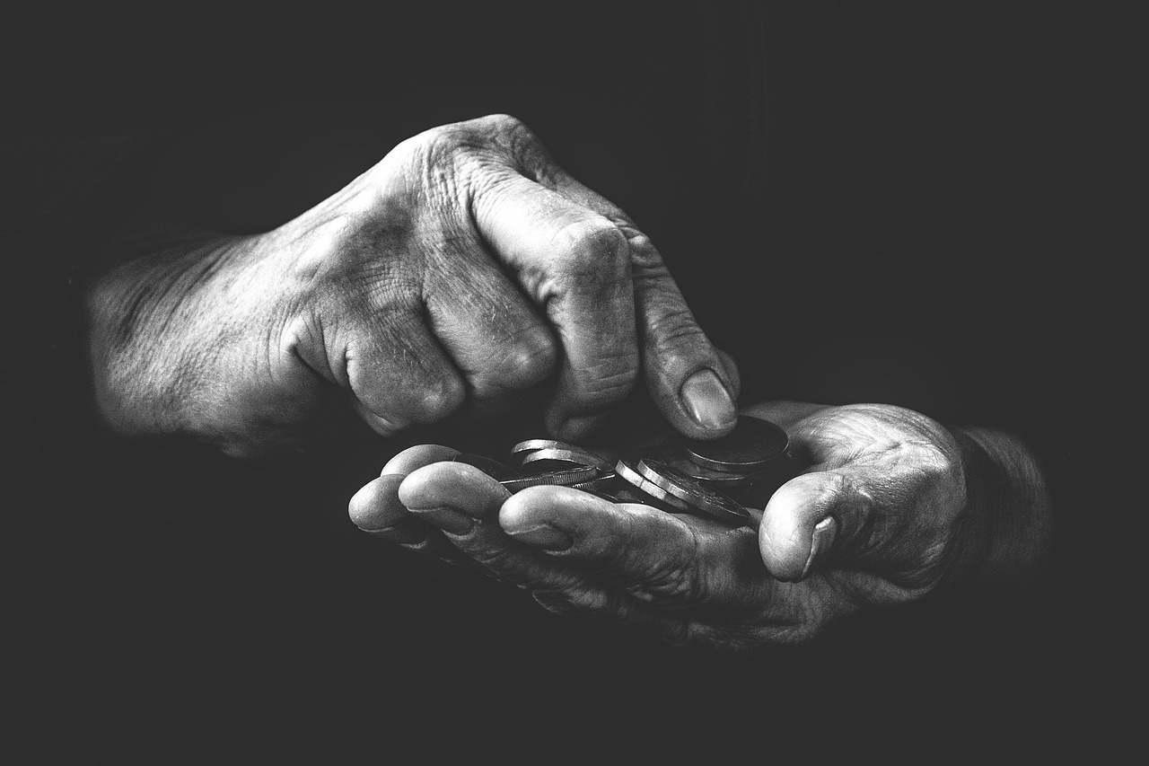 Old hands in black and white counting coins.