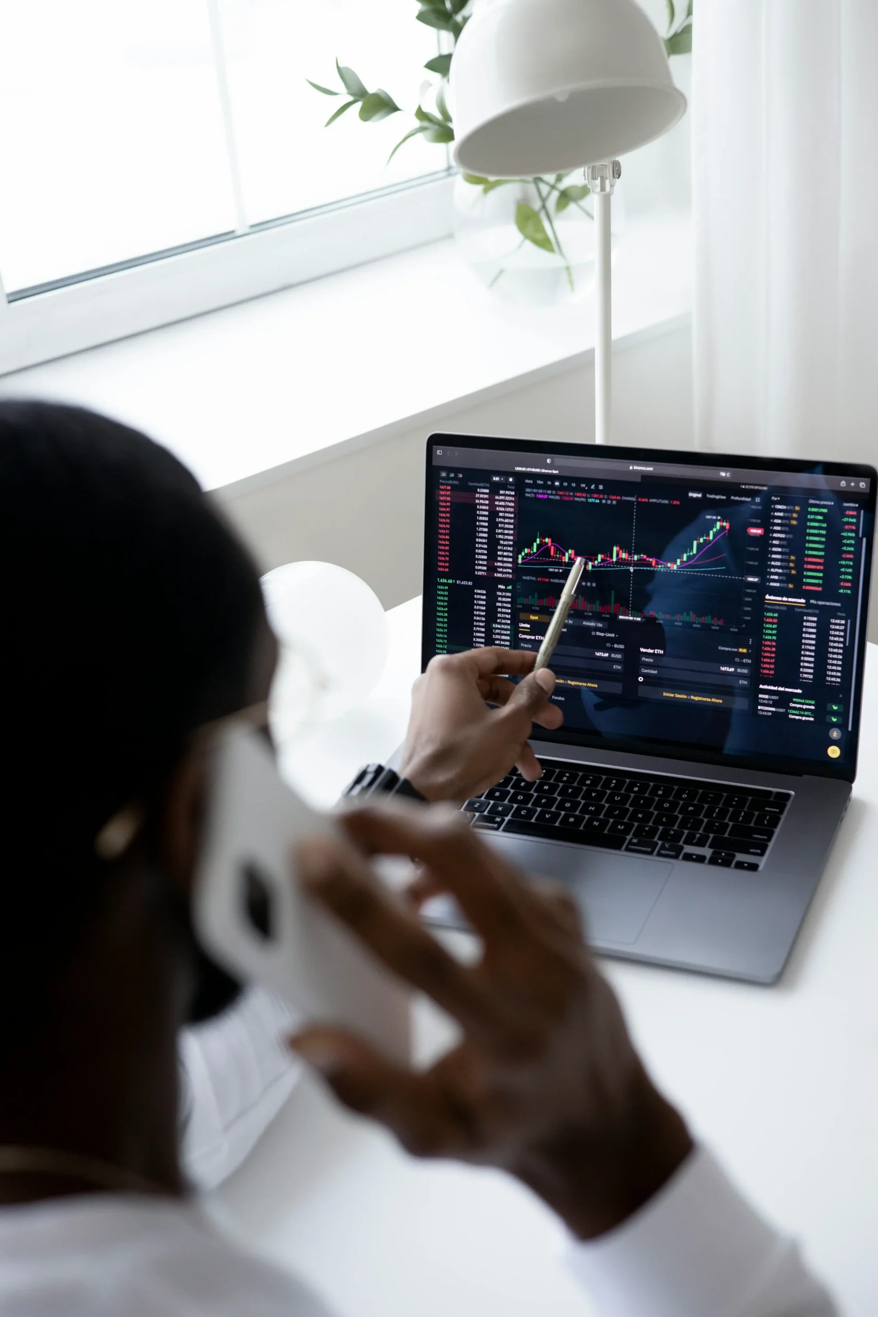 Someone looking at financial graphs on a computer.