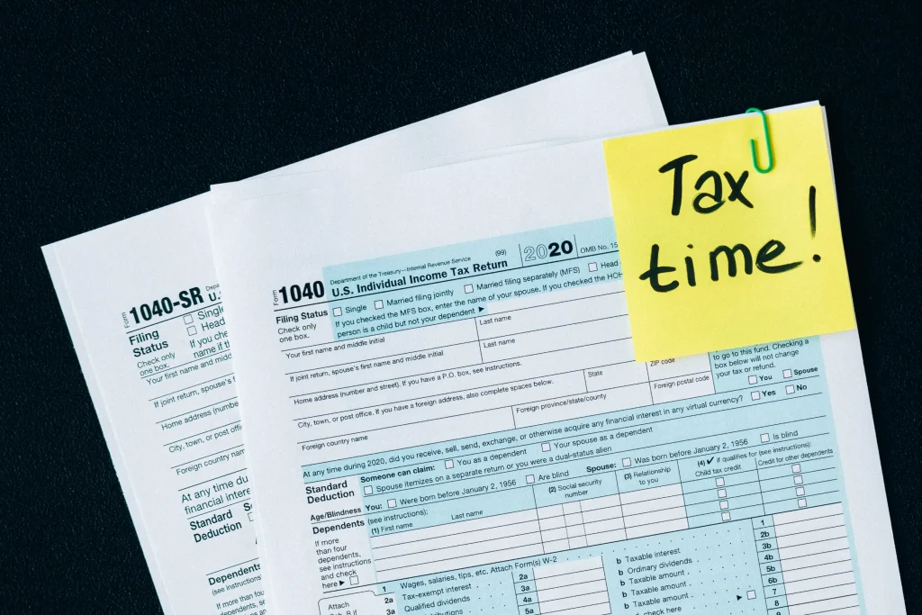 Tax forms with a sticky note that says Tax Time.