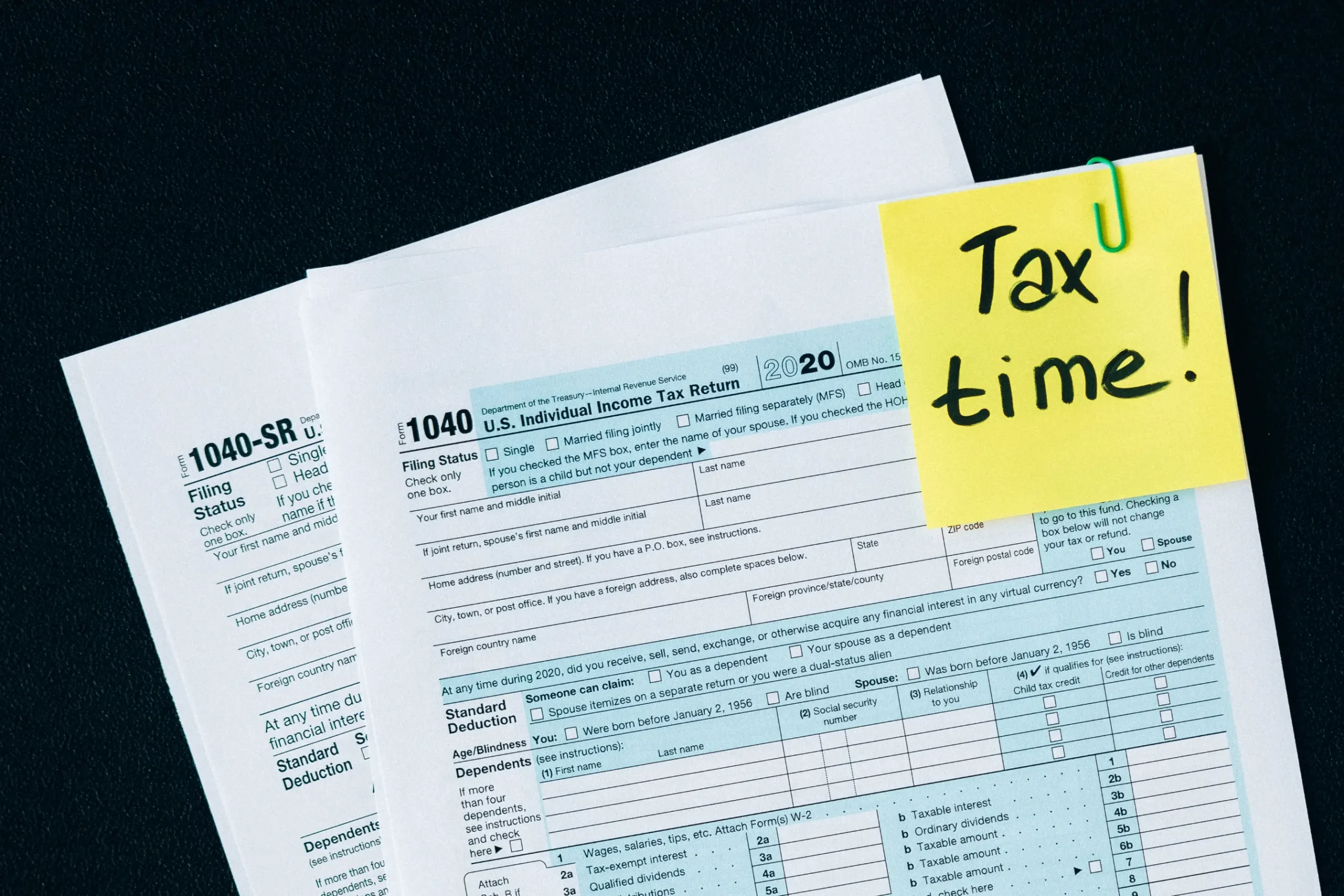 Tax forms with a sticky note that says Tax Time.