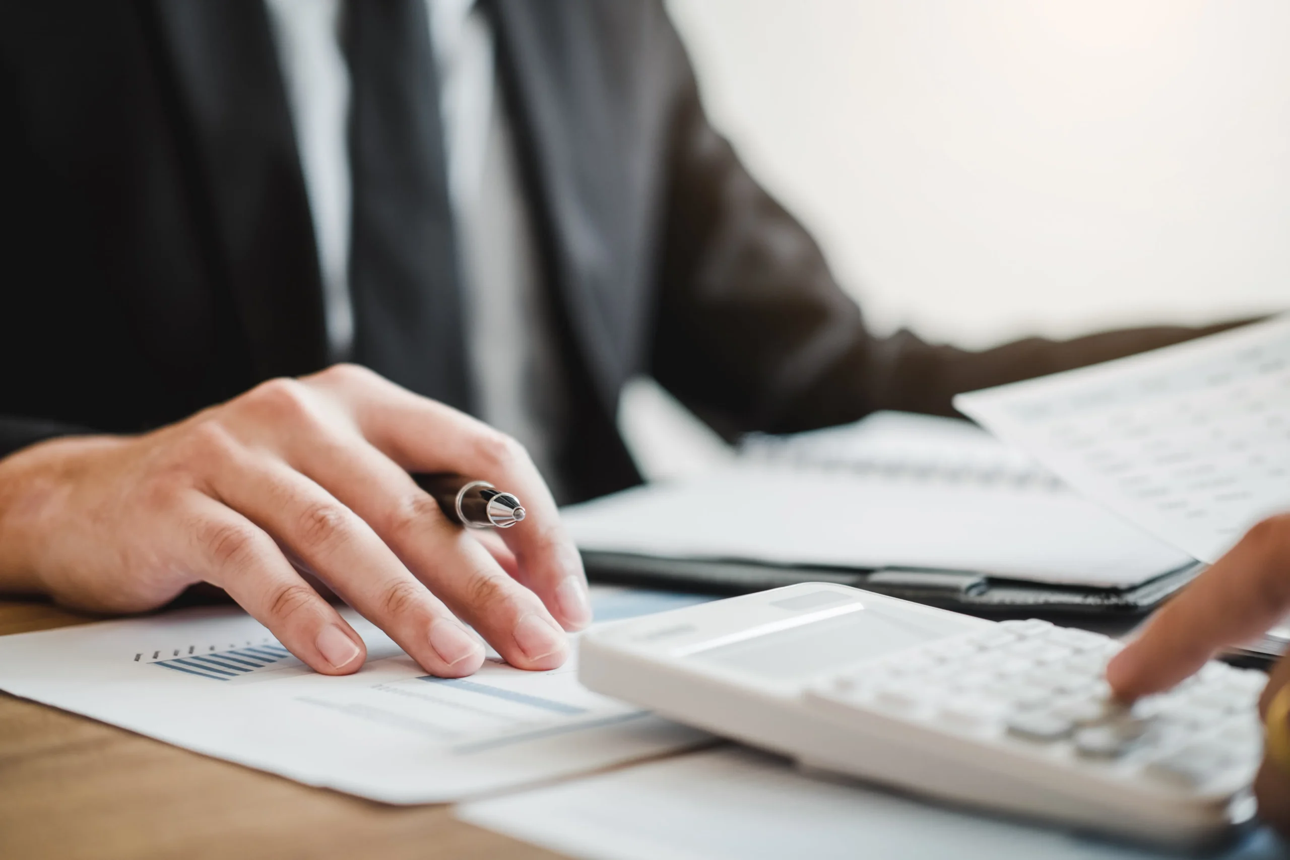 An attorney writing and using a calculator.