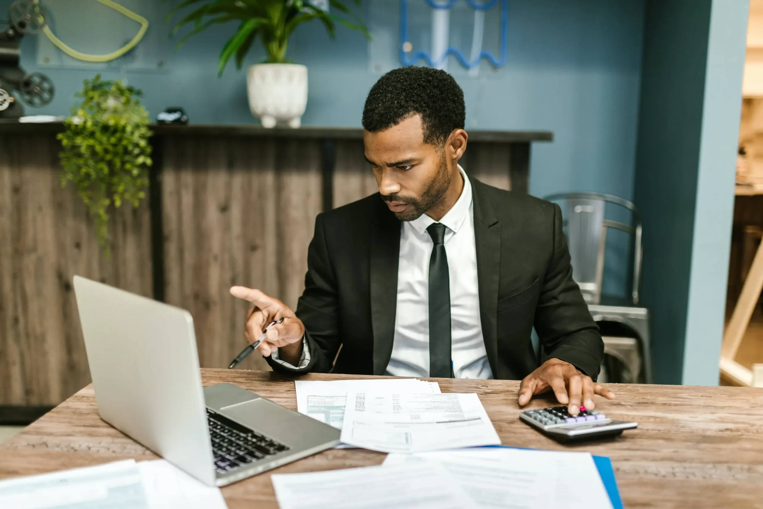 An attorney working on his computer and using a calculator.