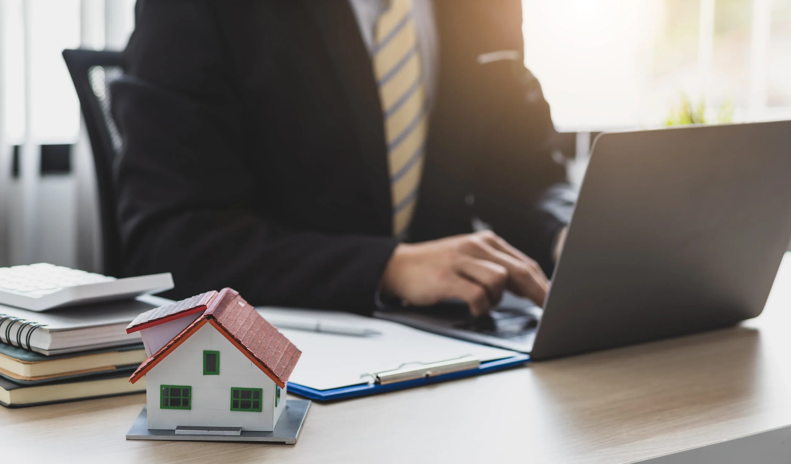 A man filing taxes next to a model home.