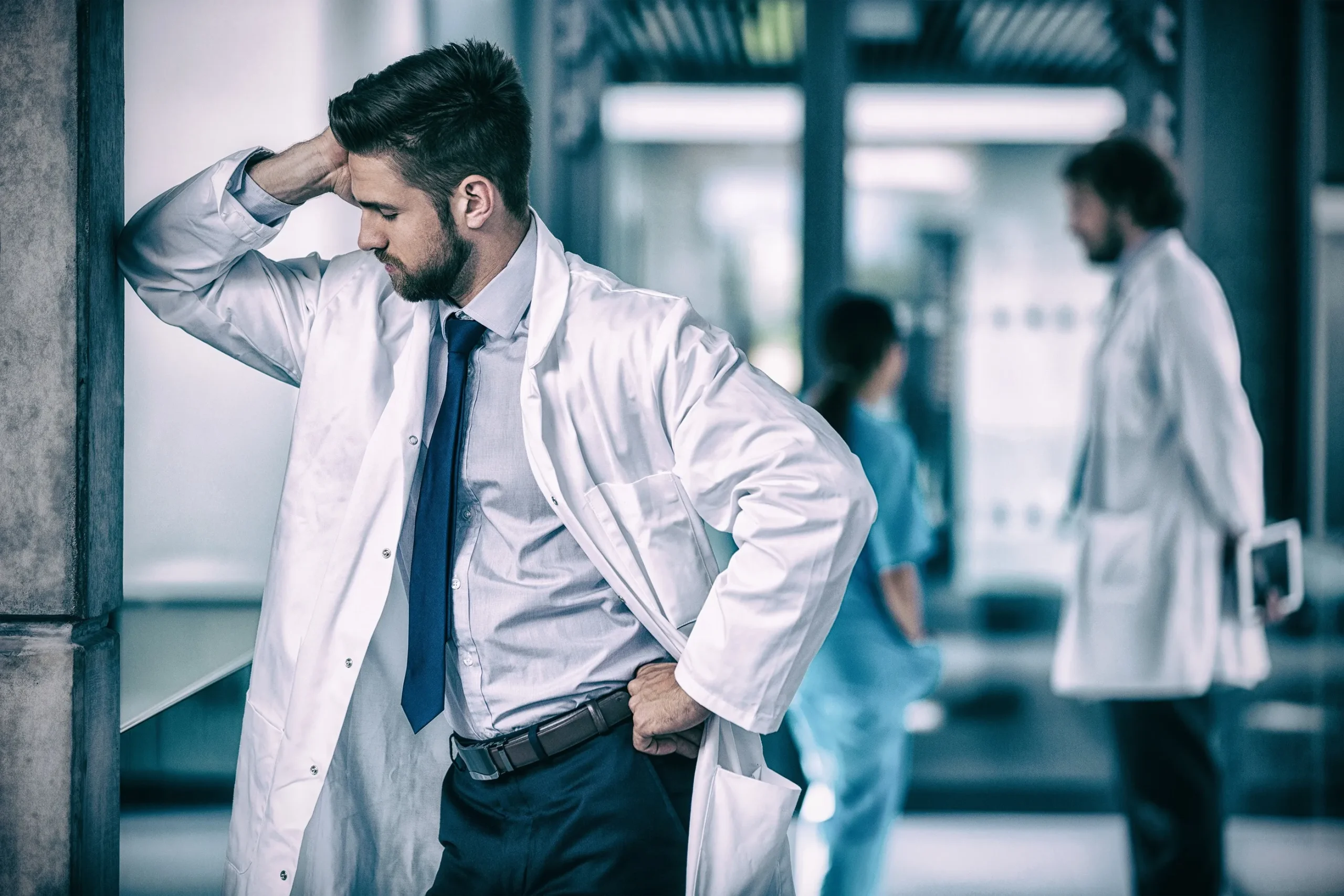 A doctor holding his head in his hand.