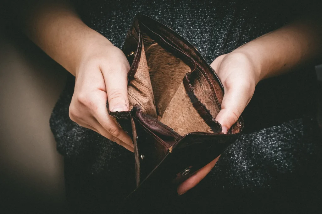 A man holding open an empty wallet.