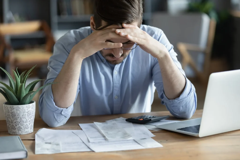 A stressed man looking over tax audit documents.