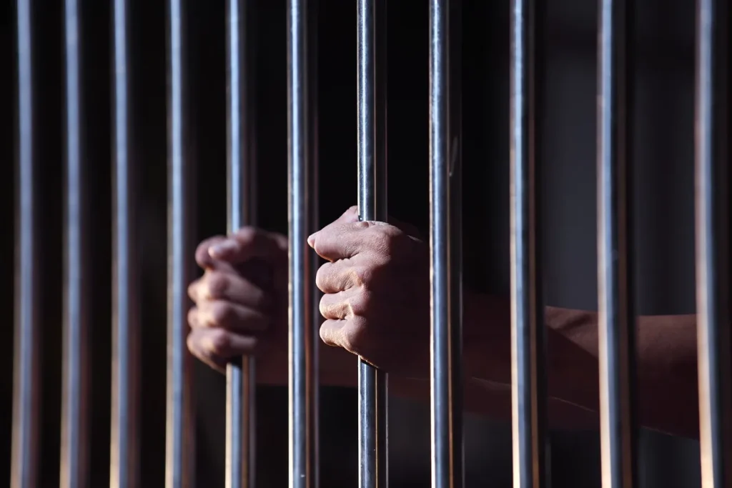 A man holding the prison bars.