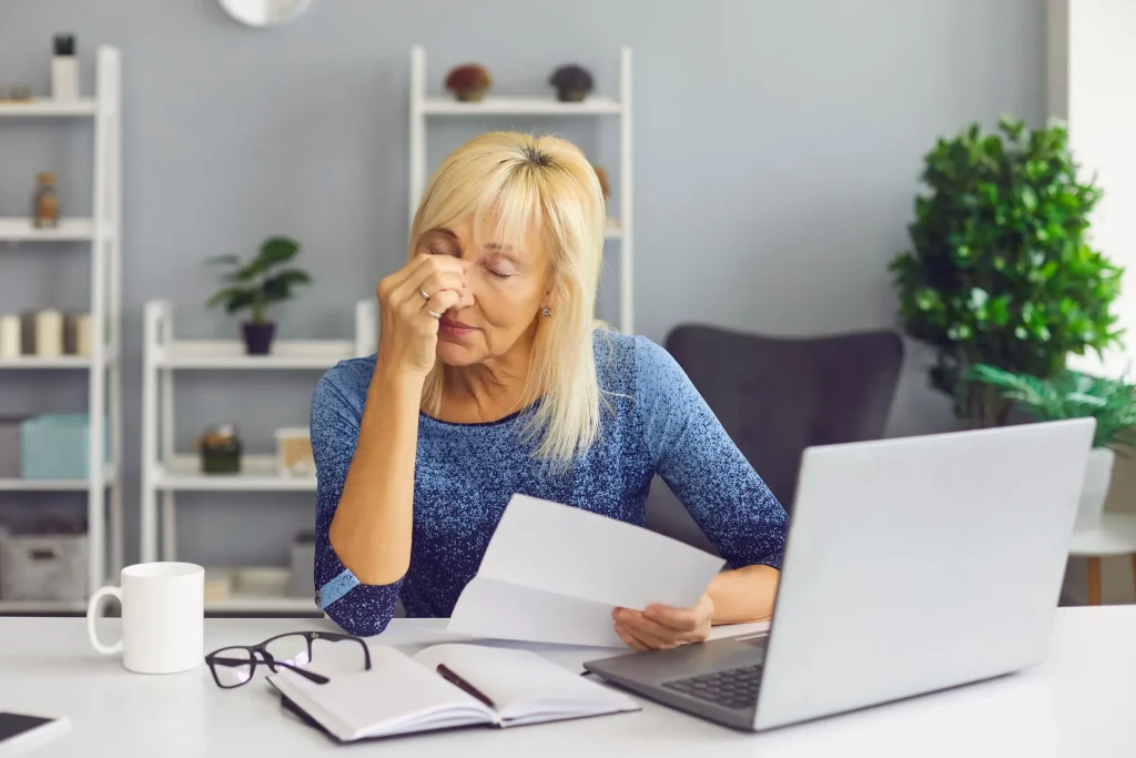 A woman looking worried looking at a notice.