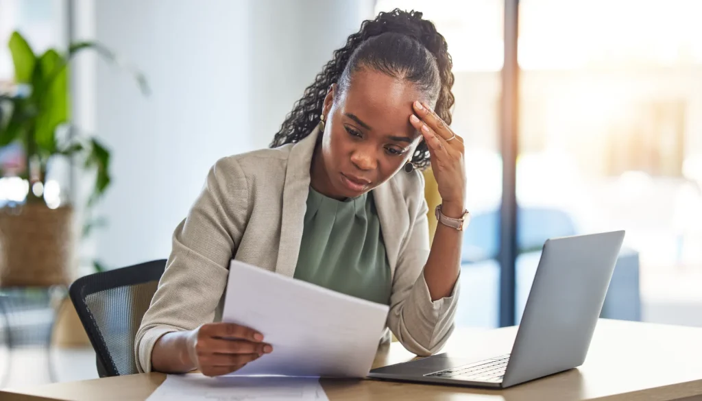 A woman worried looking at paper.