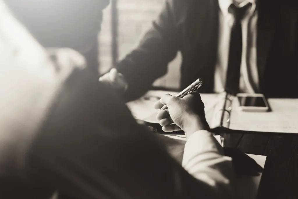 A man reviewing paperwork with a man in a suit.
